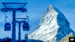 FILE - Gondolas go up next to the Matterhorn in Zermatt, Switzerland, Dec.3, 2020. 