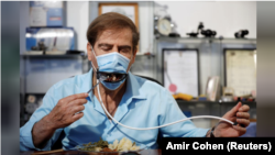 Meir Giletus, co-developer of an Israeli company, eats while wearing a mask fitted with a mechanical mouth that opens to enable diners to eat without taking it off.