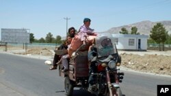 An Afghan family flees fighting as Afghan security personnel took back control of parts of the city of Herat following fighting between Taliban and Afghan security forces, on the outskirts of Herat, west of Kabul, Afghanistan. (AP)