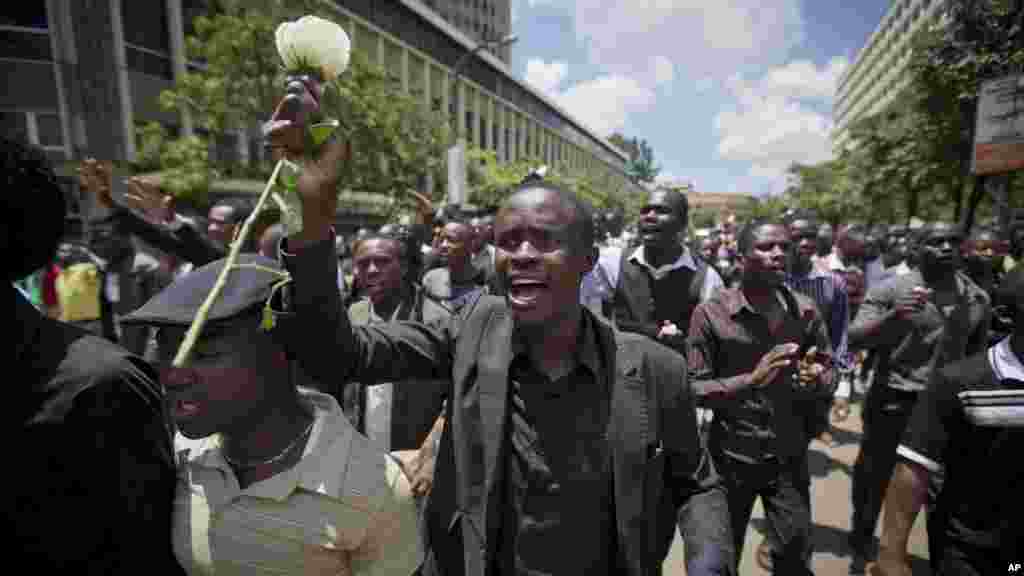 Un étudiant du Kenya, vêtu de noir pour le deuil national, tient une rose blanche au cours d'une procéssion à la mémoire des victimes de l'attaque du collège attaque Garissa, les marcheurs ont protesté contre le manque de sécurité dans le centre de Nairobi, Kenya, mardi 7 avril , 2015