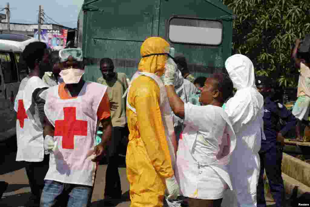 A health worker fixes another's protective suit in the Aberdeen district of Freetown, Sierra Leone, Oct. 14, 2014.