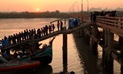 Rescuers return one of 15 bodies recovered from the Bay of Bengal after a boat filled with Rohingya refugees sank off the coast of Bangladesh Feb. 11, 2020. (Hai Do/VOA)