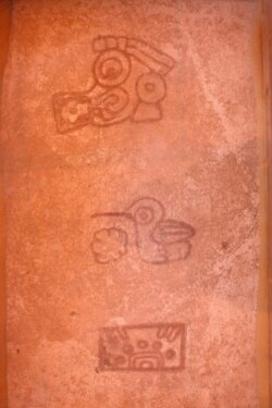 Close-up of three glyphs (from top to bottom) identified as the Teotihuacan's storm god with a square design near its mouth and a sign indicating the four cardinal directions, a bird with a long beak with a semicircular element possibly representing a water lily leaf, a rectangular calendric sign known as a reptile eye symbol with the number five, all dated to probably between 300-400 A.D. and found on the floor of the Plaza of the Glyphs at La Ventilla, an extensively-excavated neighborhood in the ancient ruins of Teotihuacan, in San Juan Teotihuacan, northeast of Mexico City, Mexico November 7, 2019. Picture taken November 7, 2019. REUTERS/Gustavo Graf