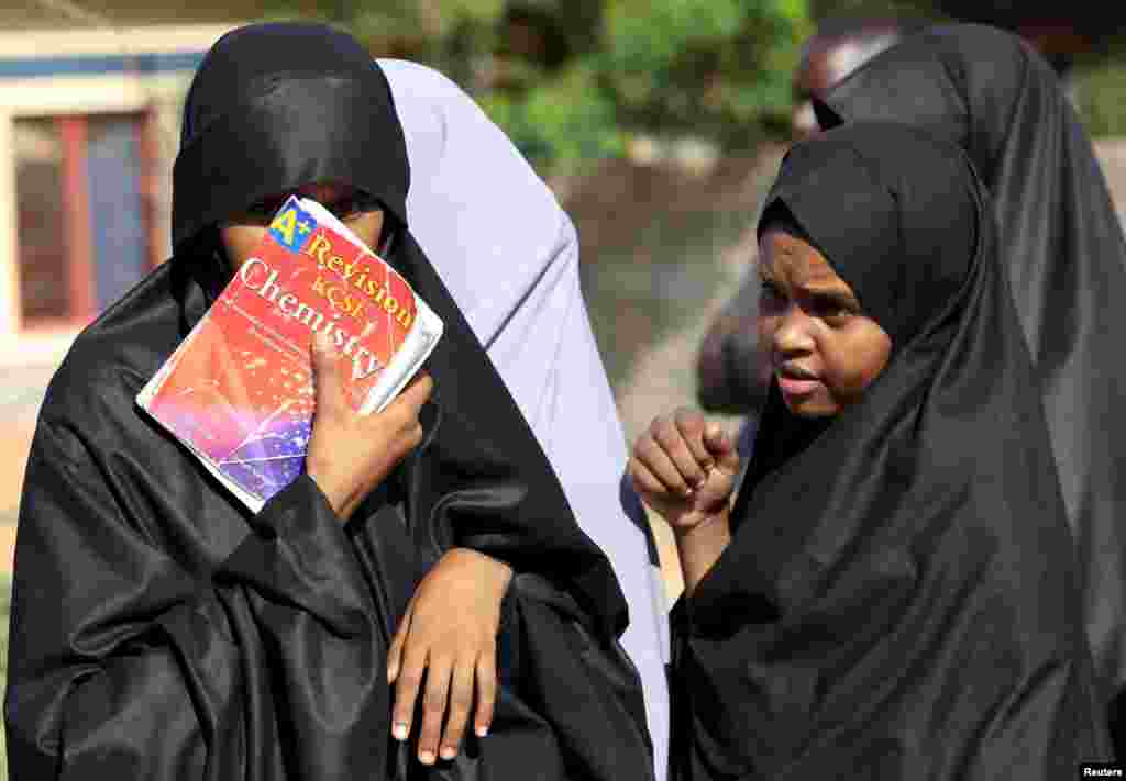 A student shields her face with a book at the main entrance of Garissa campus, the site of Thursday's attack by gunmen, in Garissa, April 3, 2015.