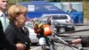 Germany's Chancellor Angela Merkel speaks near a promotional campaign bus of candidate for the European Commission presidency Jean-Claude Juncker as she arrives at an European People's Party meeting in Kortrijk, June 26, 2014.