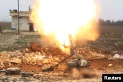 FILE - A Free Syrian Army fighter fires a shell toward Islamic State fighters in the northern Aleppo countryside, Syria.