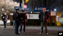 Law enforcement personnel stand in front of a Con Edison facility in the Queens borough of New York, Dec. 27, 2018, where an earlier transformer explosion lit up the night sky for several minutes.