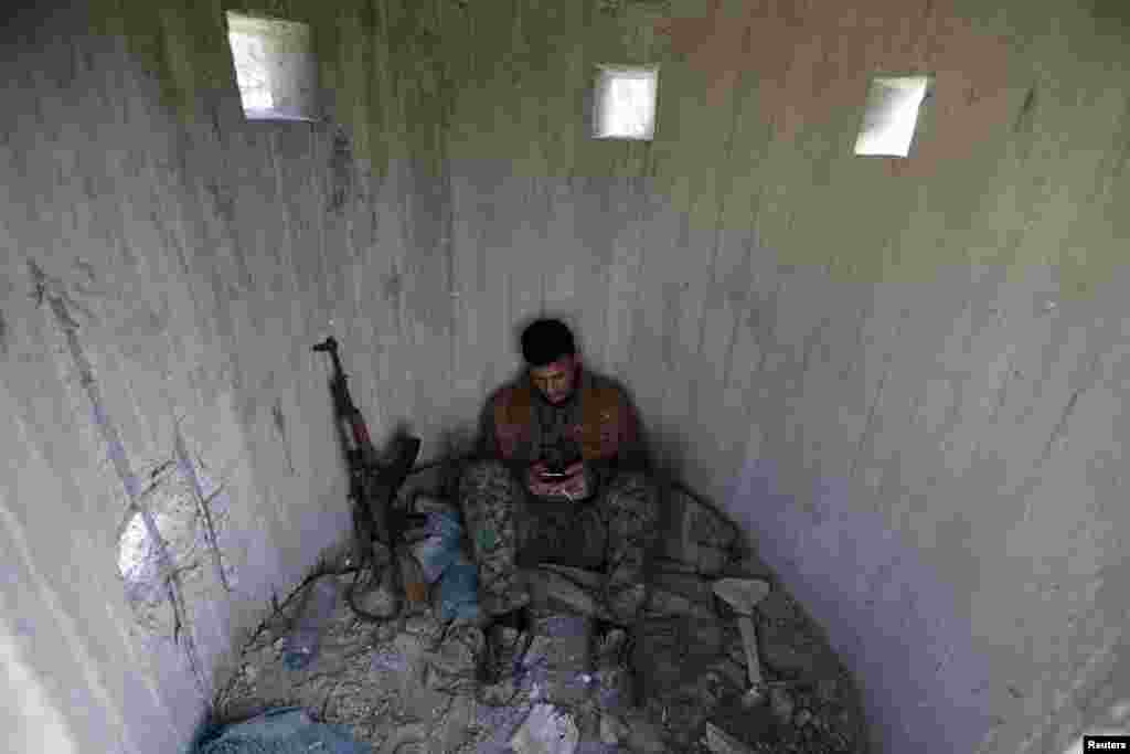 A Turkish-backed Free Syrian Army fighter rests at mount Bafliyun, in the Afrin region, Syria.