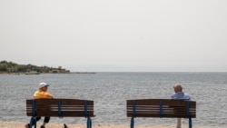 Dvojica muškaraca razgovaraju poštujući mere socijalne distance na plaži u Glifadi, predgrađu Atine, 15. maja 2020. Grčka je do sada uspela da ograniči broj smrtnih slučajeva.