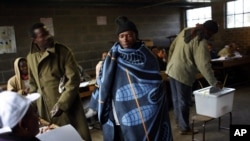 A Lesotho man wearing a traditional blanket prepares to vote at the Mpho primary school in Maseru, Lesotho, May 26, 2012.