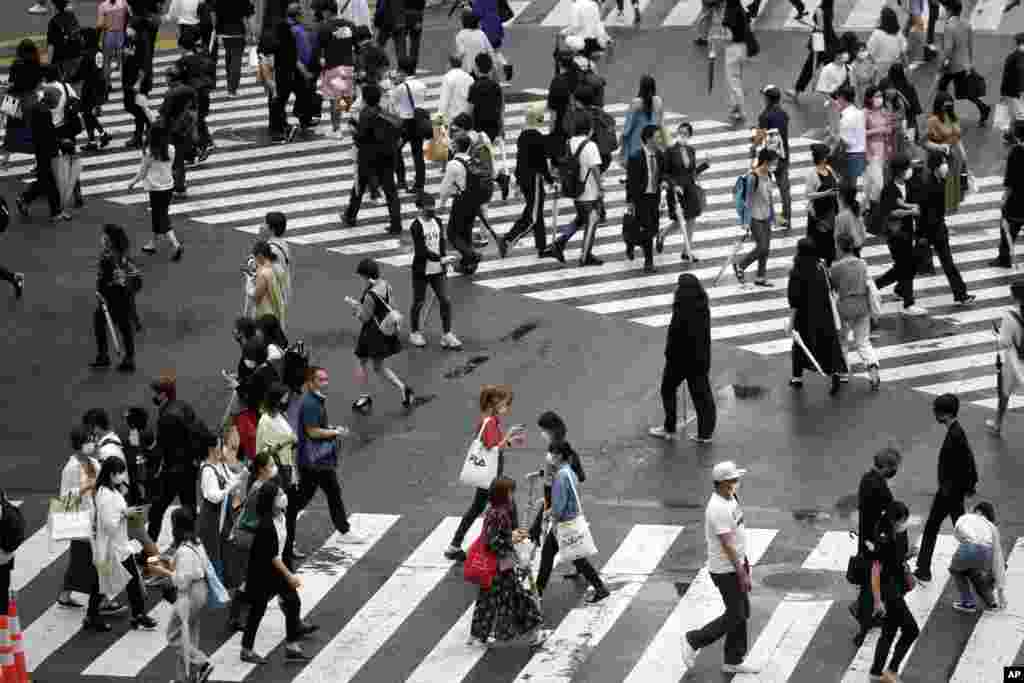People walk on pedestrian crossings Friday, July 17, 2020, at Tokyo&#39;s Shibuya district. The Japanese capital has confirmed Friday more than 290 new coronavirus cases. (AP Photo/Eugene Hoshiko)