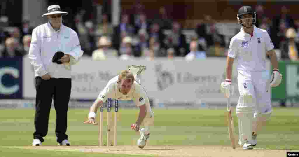 New Zealand&#39;s Neil Wagner falls over after bowling a ball as umpire Steve Davis (L) and England&#39;s Jonathan Trott (R) look on during the first test cricket match at Lord&#39;s cricket ground in London. 
