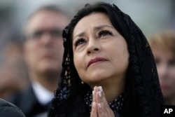 A woman prays as Pope Francis celebrates Mass at the Simon Bolivar Park in Bogota, Colombia, Sept. 7, 2017.