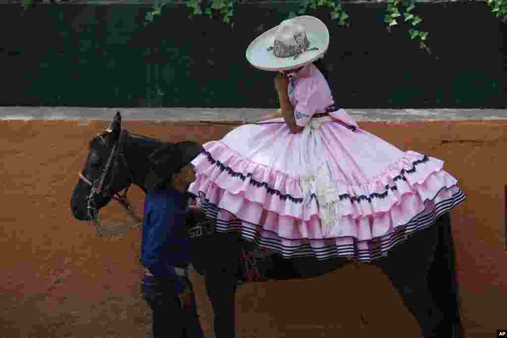 A cowboy chats with an Escaramuza before her presentation at the Rancho del Charro on the outskirts of Mexico City, Mexico, May 18, 2019.