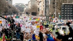 FILE - People hold the March for Our Lives rally in Washington in support of gun control, March 24, 2018. It's far from certain that the young people behind the movement will be a political force at the ballot box this fall. 