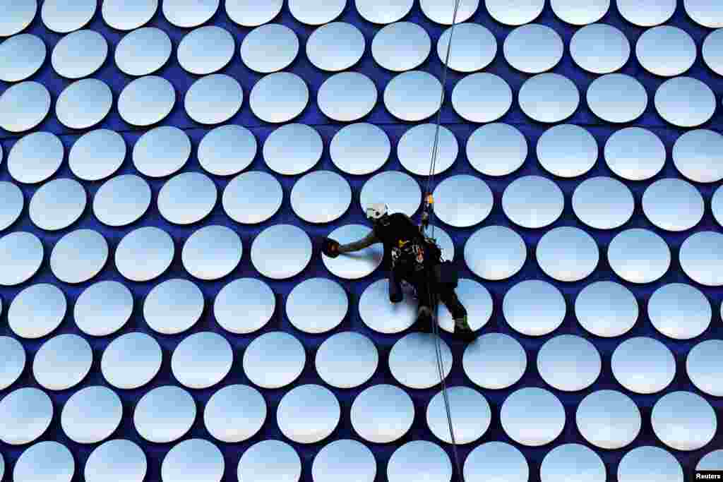 A worker cleans the Selfridges building in Birmingham, Britain.