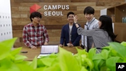 FILE - Employees of Dable, a startup and ventures investor, stand around a table during a media tour at the Google campus in Seoul, South Korea, May 8, 2015. 