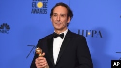 Alexandre Desplat poses in the press room with the award for best original score - motion picture for "The Shape of Water" at the 75th annual Golden Globe Awards at the Beverly Hilton Hotel, Jan. 7, 2018, in Beverly Hills, Calif.