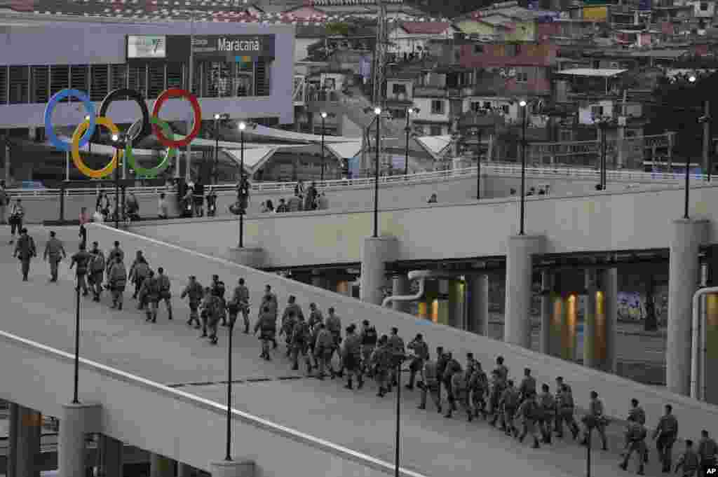 Tentara melewati cincin-cincin Olimpiade di Stadion Maracana menjelang upacara pembukaan Olimpiade Musim Panas 2016 di Rio de Janeiro, Brazil (5/8).&nbsp;(AP/Jae C. Hong)