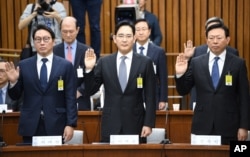SK Group chairman Chey Tae-Won, left, Samsung Electronics Vice Chairman Lee Jae-yong, center, and Lotte Group Chairman Shin Dong-Bin take an oath during a parliamentary probe into a scandal engulfing President Park Geun-hye at the National Assembly in Seoul, South Korea.