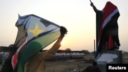 A woman carries a South Sudan flag as she arrives at the John Garang Mouselium for the Independence Day celebrations in the capital Juba July 9, 2011.