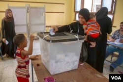A woman casts her ballot at a polling station in the neighborhood of Bashteel in Giza, Egypt, in the 2014 elections.(H. Elrasam/VOA)