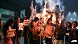 Student activists burn effigies of India's Prime Minister and Chief Minister of Assam in Guwahati, India, on Jan, 8, 2019, after India's lower house passed legislation that will grant citizenship to members of certain religious minorities but not Muslims.