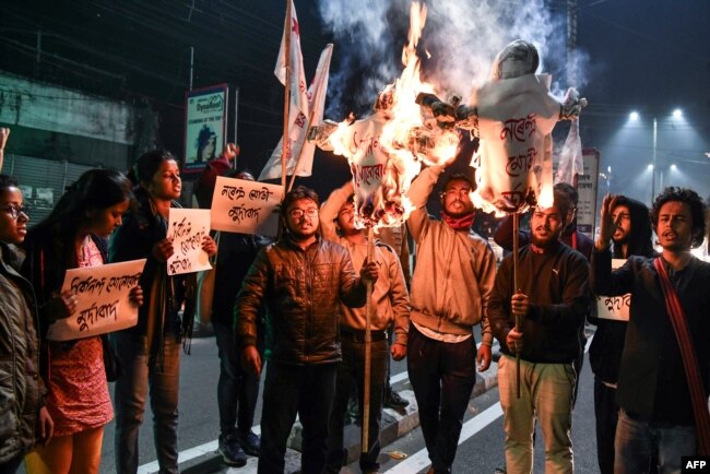 Student activists burn effigies of India's prime minister and chief minister of Assam in Guwahati, India, on Jan, 8, 2019, after India's lower house passed legislation that will grant citizenship to members of certain religious minorities but not Muslims.