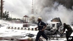 6月11号尼日利亚紧急救援人员在遭到袭击的警察局外奔走