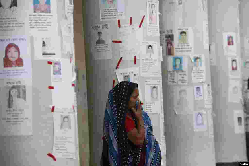 A woman waits for news of her relative, a garment worker, who is missing after the collapse of Rana Plaza building, in front of missing people posters in Savar, Bangladesh, April 30, 2013. 
