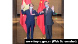 Bộ trưởng Ngoại giao Việt Nam Bùi Thanh Sơn (trái) gặp Ủy viên Quốc vụ viện – Bộ trưởng Ngoại giao Trung Quốc Vương Nghị tại Trùng Khánh vào ngày 8/6/2021.