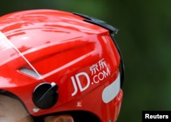 FILE - A logo of JD.com is seen on a helmet of a delivery man in Beijing, China, June 16, 2014.