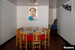 A portait of former Chinese leader Mao Zedong hangs above a dining table in a restaurant next to the Red Culture Training Center in the mountains outside Jinggangshan, Jiangxi province, China, Sept. 14, 2017.