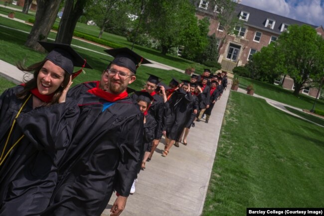 FILE: Barclay College graduates Taylor Mabry and Ryan Kucharek walk across campus to commencement ceremonies. Haviland, Kansas. May 2019