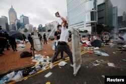 A protester throws a brick during a demonstration against a proposed extradition bill, in Hong Kong, June 12, 2019.
