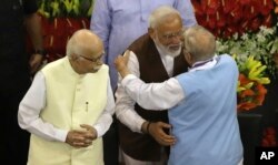 Indian Prime Minister Narendra Modi, second right, hugs senior Bharatiya Janata Party leader M.M. Joshi as L.K. Advani, left, watches after Modi's election as ruling alliance leader, in New Delhi, May 25, 2019.