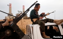 FILE - A fighter from Misrata sits on top of a vehicle near Sirte, March 16, 2015.