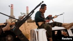 A fighter from Misrata sits on top of a vehicle near Sirte, March 16, 2015. 