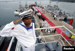 A Cambodian Navy sailor salutes on a Chinese naval patrol boat during a handover ceremony at a Cambodian naval base at Ream in Sihanouk Ville province, southwest of Phnom Penh, November 7, 2007.