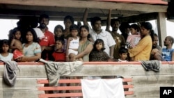 FILE - Sri Lankan migrants bound for Australia remain on board their boat docked at a port in Cilegon, Banten province, Indonesia, after they were intercepted by the Indonesian navy, Oct.14, 2009.