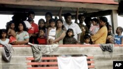 FILE - Sri Lankan migrants bound for Australia remain on board their boat docked at a port in Cilegon, Banten province, Indonesia, after they were intercepted by the Indonesian navy.