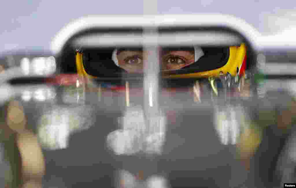 Tay đua Fernando Alonso ngồi trong xe trong buổi tập đầu tiên tại giải đua xe Grand Prix Công thức Một của Úc ở Melbourne.