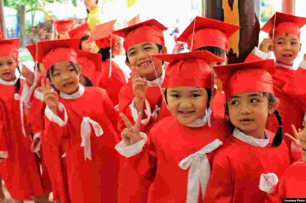 Children smile pose for a photograph during their pre-school graduation at Childhood Kindergarten in Phan Thiet, the capital of B&igrave;nh Thuận province in southeastern Vietnam. (Photo by Nguyễn Th&aacute;i B&igrave;nh/Vietnam/VOA reader)