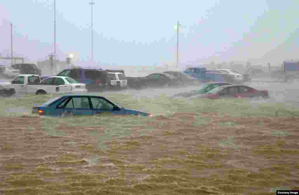 Rain and heavy winds in 2003 from Hurricane Isabel flood fleet parking at Naval Station Norfolk, trapping vehicles in water as high as their windows. (Credit: U.S. Navy)