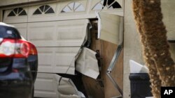 The battered garage door of Enrique Marquez is seen after a recent FBI raid, in Riverside, California, Dec. 9, 2015. 