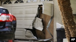 The garage door of Enrique Marquez's home is seen broken after a recent FBI raid, Dec. 9, 2015, in Riverside, California.