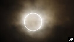 La luna se atraviesa frente al son, mostrando un halo de luz durante el eclipse anular en Yokohama, Japón.