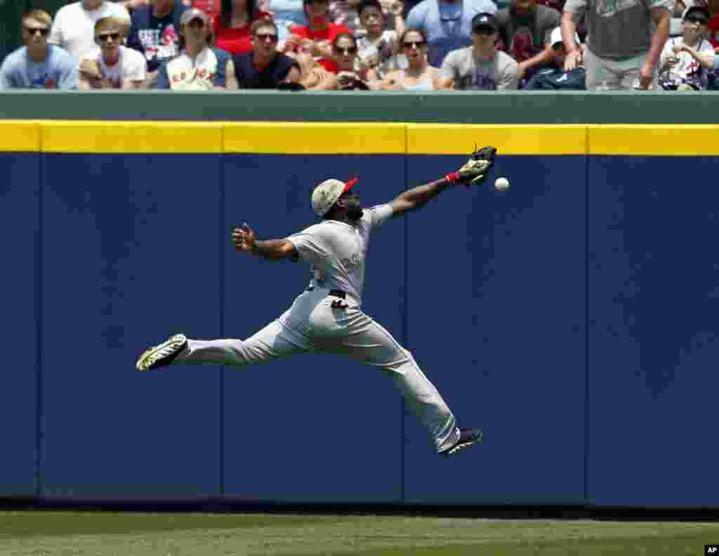 Boston Red Sox outfielder Jackie Bradley tries to reach a 2-RBI double hit over his head by Atlanta Braves&#39; Justin Upton during the third inning of a baseball game in Atlanta, Georgia, USA, May 26, 2014.