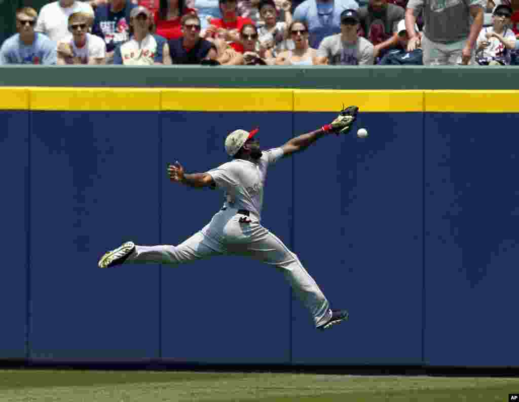 Pemain bisbol klub Boston Red Sox Jackie Bradley gagal menangkap bola pada pertandingan di kota Atlanta, Georgia, AS.