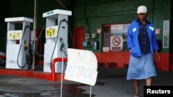 A woman walks past a "No Petrol" sign at a fuel station in Harare, Zimbabwe, Oct. 9, 2018. 